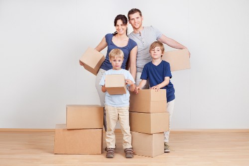 Mover wearing PPE while carrying furniture during relocation